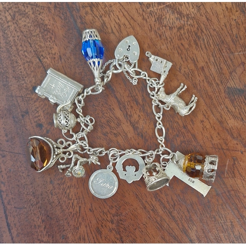 4 - Silver charm bracelet with 12 varying charms three gem set. Hallmarks Birmingham and Ireland. Weight... 