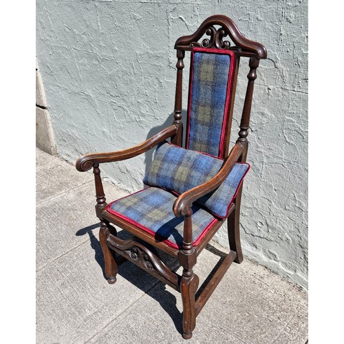 100 - A Jacobean style mahogany carver armchair with high decorative back, arm rests and stretcher. Uphols... 