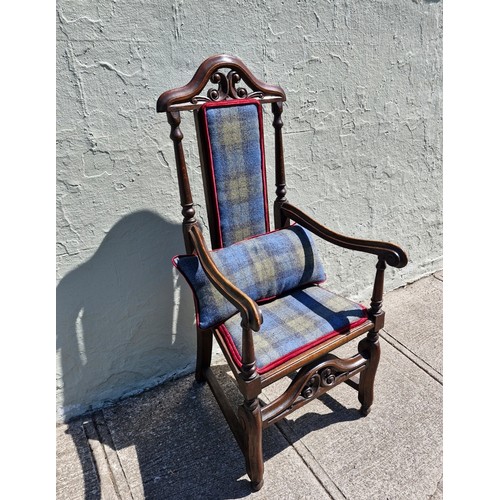 100 - A Jacobean style mahogany carver armchair with high decorative back, arm rests and stretcher. Uphols... 