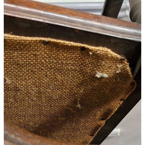 100 - A Jacobean style mahogany carver armchair with high decorative back, arm rests and stretcher. Uphols... 