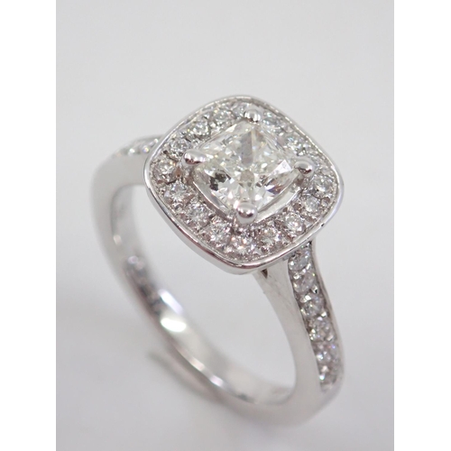 14 - A diamond halo cluster ring set with diamond shoulders in 18ct gold, estimated weight of main diamon... 
