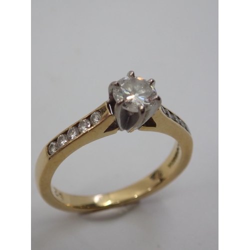 18 - A diamond solitaire ring set with diamond shoulders