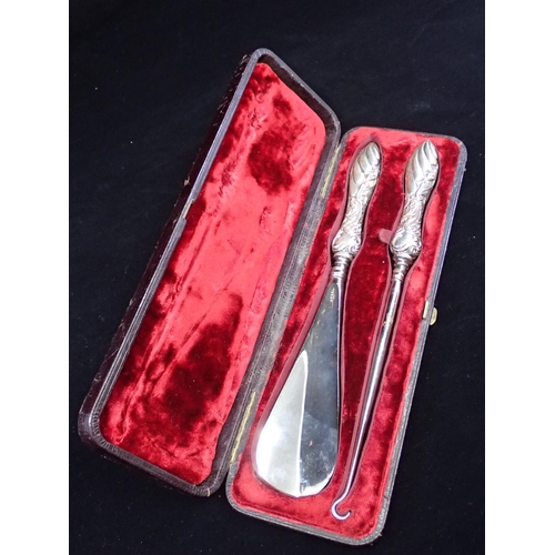 192 - A silver mounted button hook and silver mounted shoe horn in a fitted box.