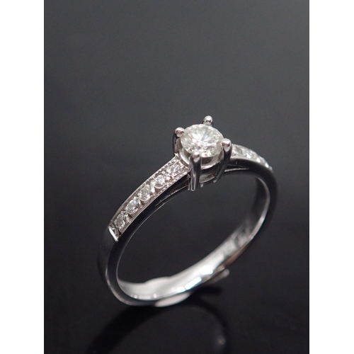 131 - A diamond solitaire ring set with diamond shoulders, approx. 3 grams finger size L