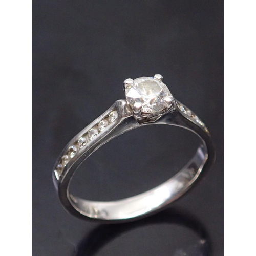 178 - A diamond solitaire ring set with diamond shoulders finger size O half