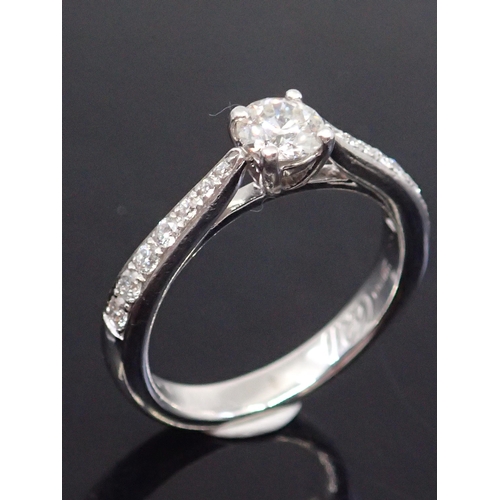 327 - A diamond solitaire ring set with diamond shoulders, finger size K set in platinum