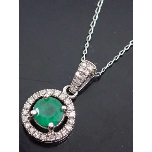 32 - An emerald and diamond cluster pendant on a gold chain