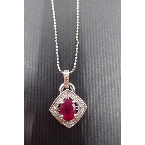 34 - A ruby and diamond cluster pendant on an 18ct gold chain