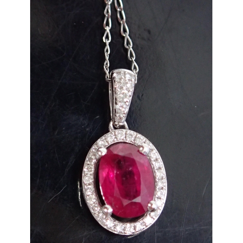 36 - A ruby and diamond cluster pendant on an 9ct gold chain