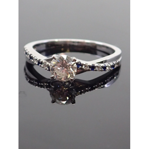 17 - A diamond solitaire ring set with diamond and  synthetic sapphire shoulders in 18ct gold, with a GIA... 