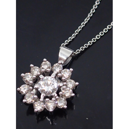 21 - A diamond flower pendant set in 18ct gold on a 18ct gold chain