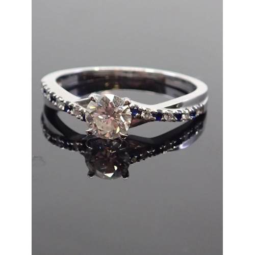 12 - A diamond solitaire ring set with diamond and  synthetic sapphire shoulders in 18ct gold, with a GIA... 