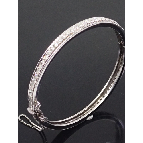 128 - A 14ct gold diamond set bangle, total estimated weight 3.5cts