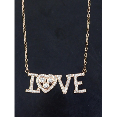 65 - A diamond set 18ct gold love necklace