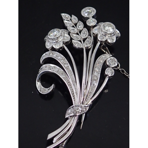 11 - A fine diamond set flower spray brooch approx. 12 grams, (we note one tiny diamond tests a lab grown... 