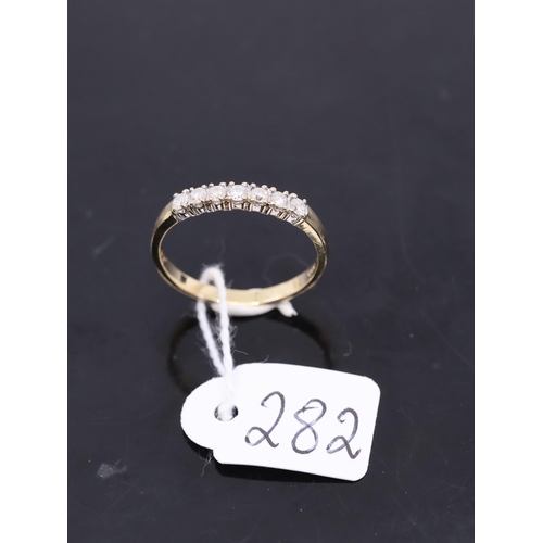 282 - A diamond seven stone gold ring, showing as finger size S