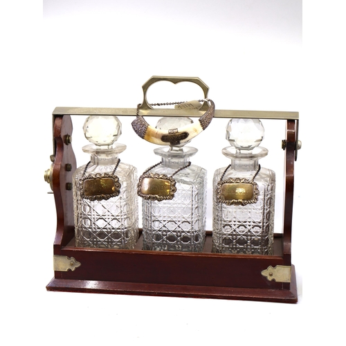 368 - A three bottle glass tantalus with silver wine lables