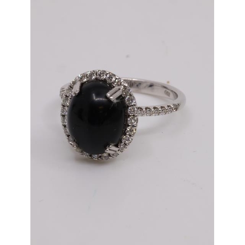 28 - A black gem stone and diamond cluster ring set in 18ct gold finger size P