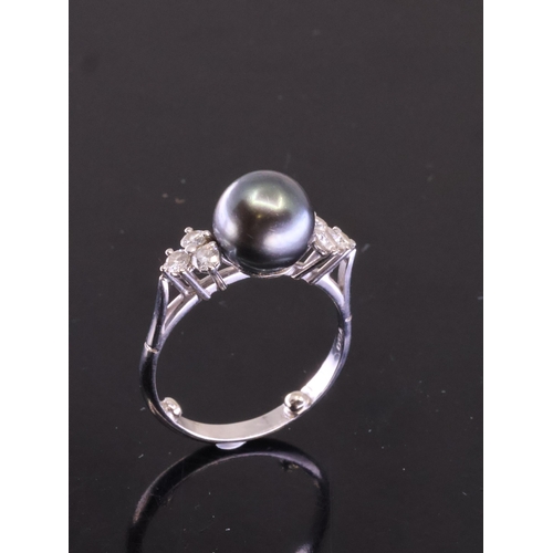 207 - A pearl and diamond ring set in 18ct gold, finger size O (Two ball spacers in shank of ring)