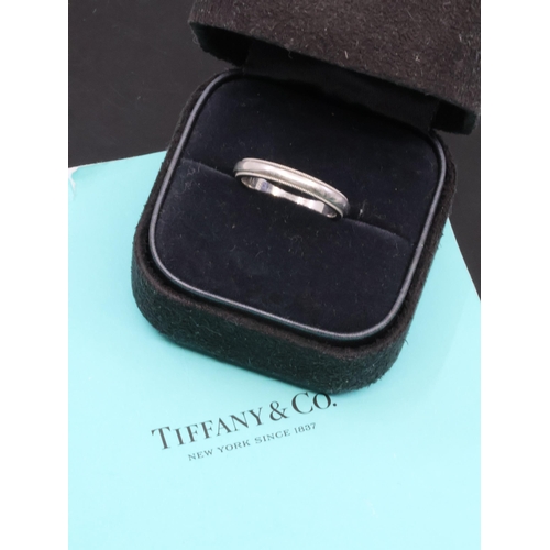 14 - A platinum Tiffany wedding ring in box and with papers showing €840 was paid in 2018 finger size M h... 