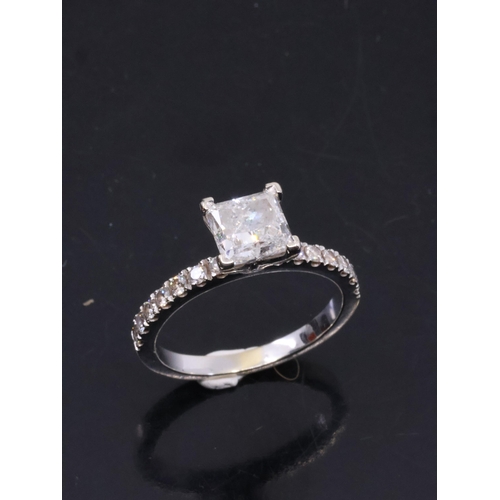 23 - A princess cut diamond solitaire ring set with diamond shoulders, with a IGI cert which states the d... 