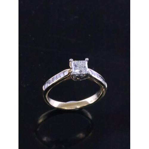 165 - A diamond solitaire ring set with diamonds shoulders in 18ct gold, with a IGI cert which states the ... 