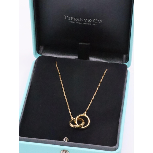 104 - An 18ct gold Tiffany Atlas X Closed Interlocking Pendant in box with a copy of a receipt which shows... 