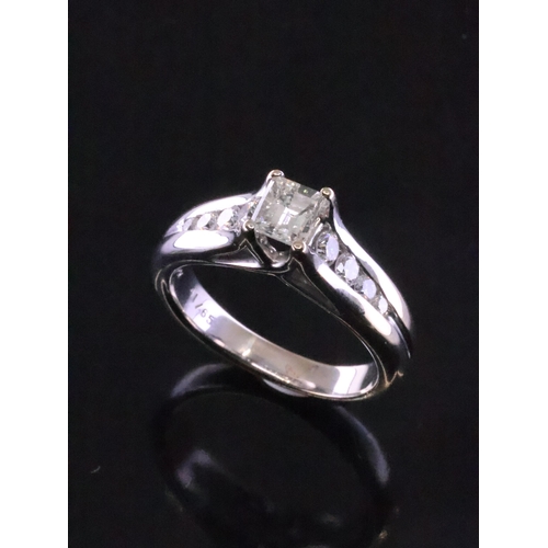 83 - An 18ct gold solitaire diamond ring set with diamond shoulders finger size N