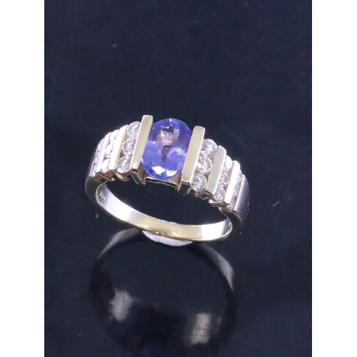 85 - A diamond and tanzanite ring set in 14ct gold finger size R