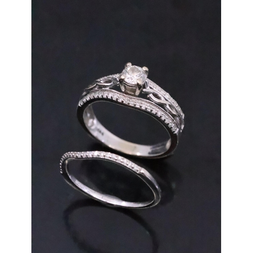 23 - A diamond solitaire ring set with diamond shoulders in a celtic design with a diamond set band in 14... 