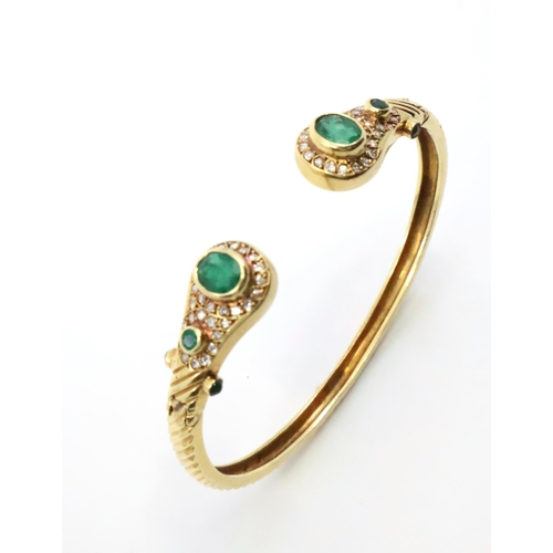 57 - An 18ct gold, diamond and emerald bangle