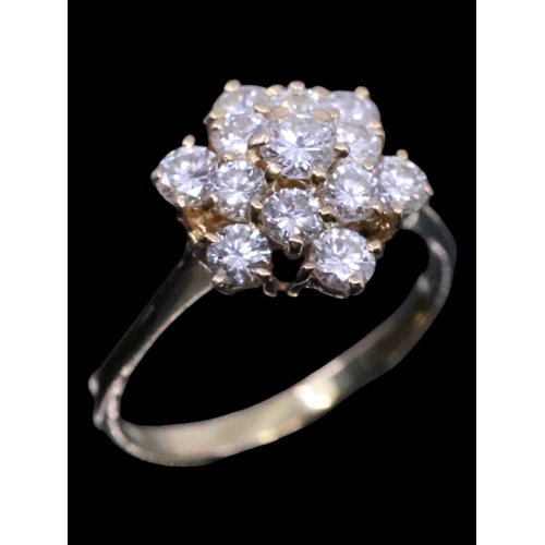 23 - A diamond cluster ring set in 18t gold, showing as finger size K and a half