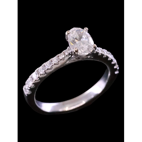 65 - A diamond solitaire ring set  in 18ct gold with diamond shoulders with a GIA which states the diamon... 