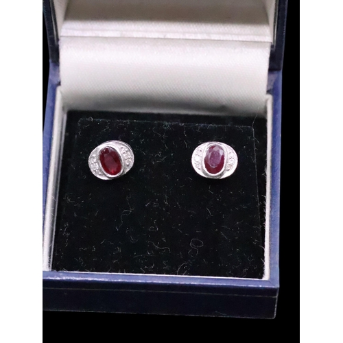 173 - A pair of diamond and gem set earrings