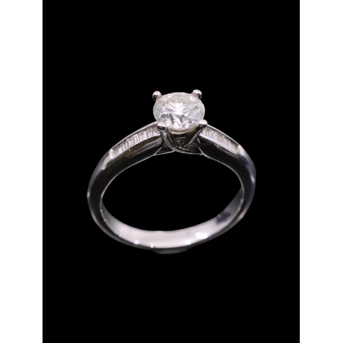 15 - A diamond solitaire ring set with diamond shoulders in 18ct gold finger size M estimated weight of d... 