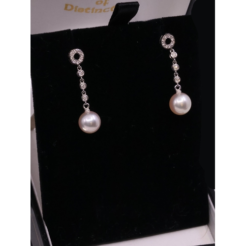 20 - A pair of diamond and pearl set earrings in 18ct gold