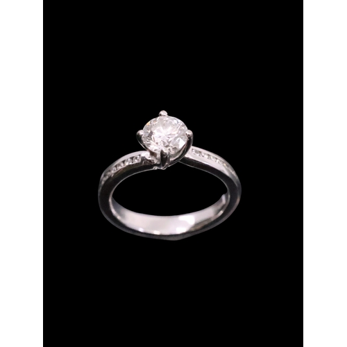 23 - A diamond solitaire ring set with diamond shoulders set in 18ct gold, with a copy of a GIA cert whic... 