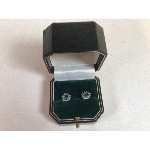 56 - A pair of diamond and emerald stud earrings set in yellow metal