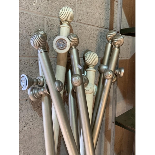 Nine curtain poles and fittings for tie backs.