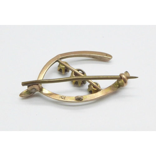 1075 - A 9ct gold and garnet wishbone brooch, 1.7g