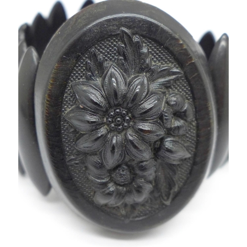 1002 - A Victorian Whitby jet bracelet set with a carved oval panel, (panel 5cm, possibly bog oak)