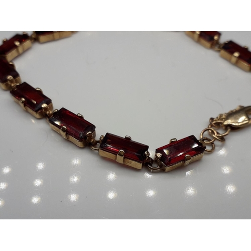 1053 - A 9ct gold and fire garnet bracelet, 12.2g