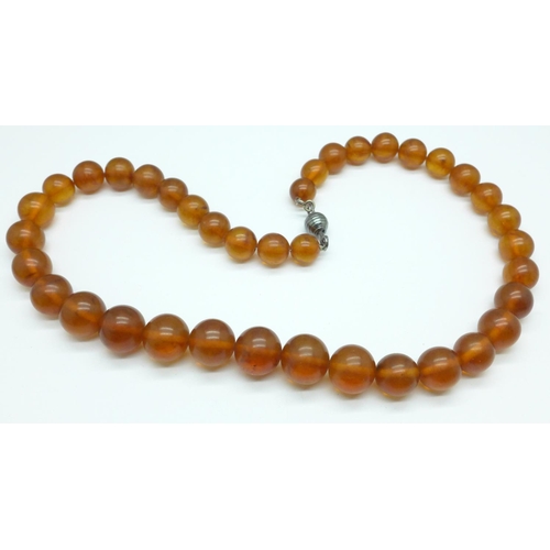 1079 - An amber necklace, 63g