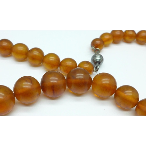 1079 - An amber necklace, 63g