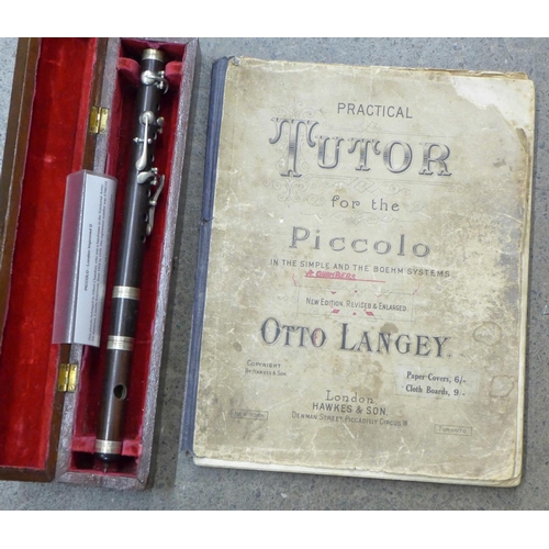 699 - A cased Piccolo and a Practical Tutor instruction book