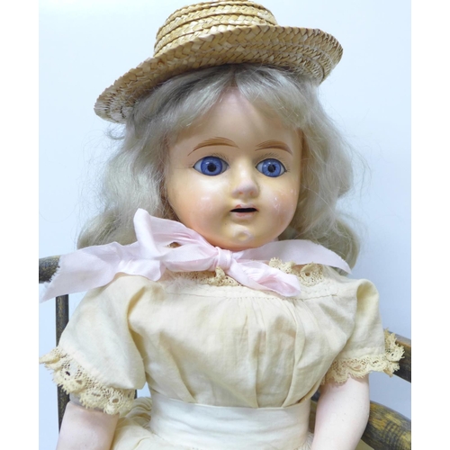 770 - A composite doll and a doll's wooden baby chair