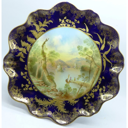 792 - An Aynsley tazza, with a blue and gold border and decoration, having a central hand painted landscap... 