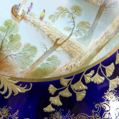 792 - An Aynsley tazza, with a blue and gold border and decoration, having a central hand painted landscap... 