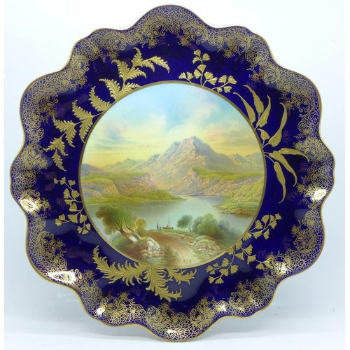 794 - An Aynsley tazza, with a blue and gold border and decoration, having a central hand painted landscap... 