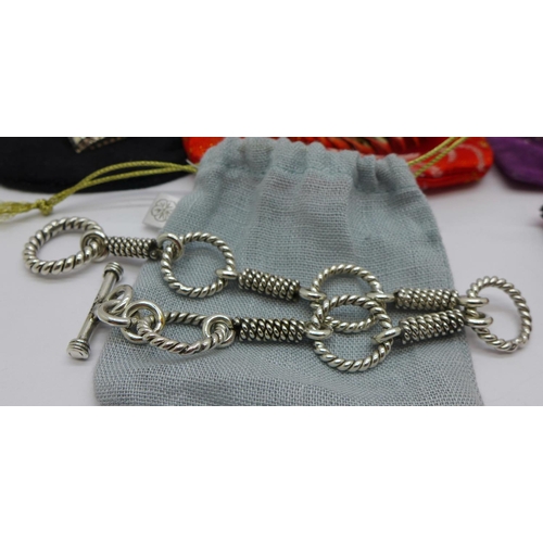 846 - Three silver bracelets, including a heavy articulated fish bracelet, (71g), a silver bangle, a silve... 